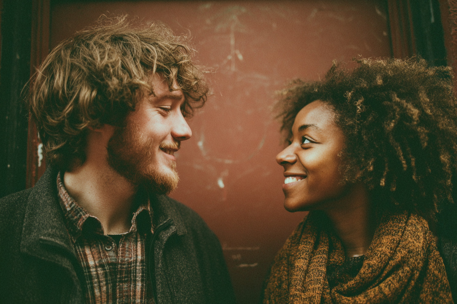 Ein weißer Mann und eine Schwarze Frau schauen sich lächelnd an.